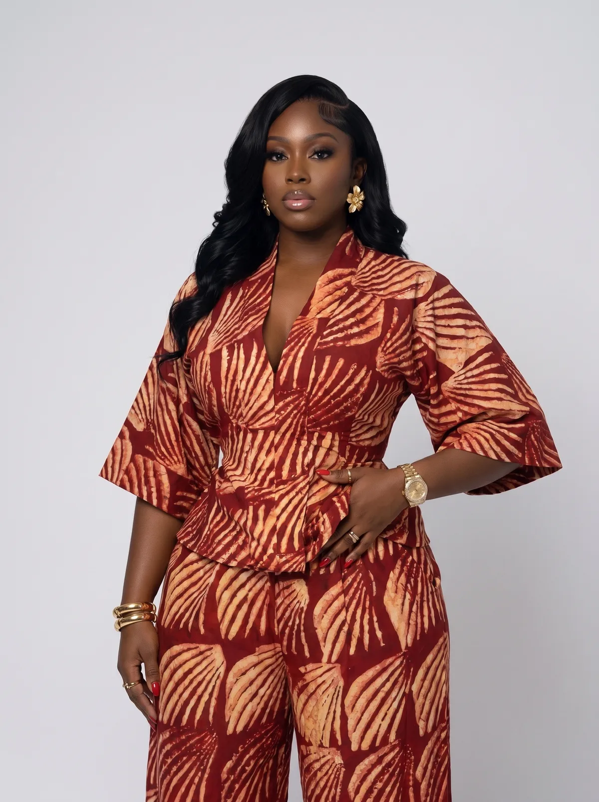 Closer studio portrait of a fictional adult Black woman wearing a rust patterned tailored set
