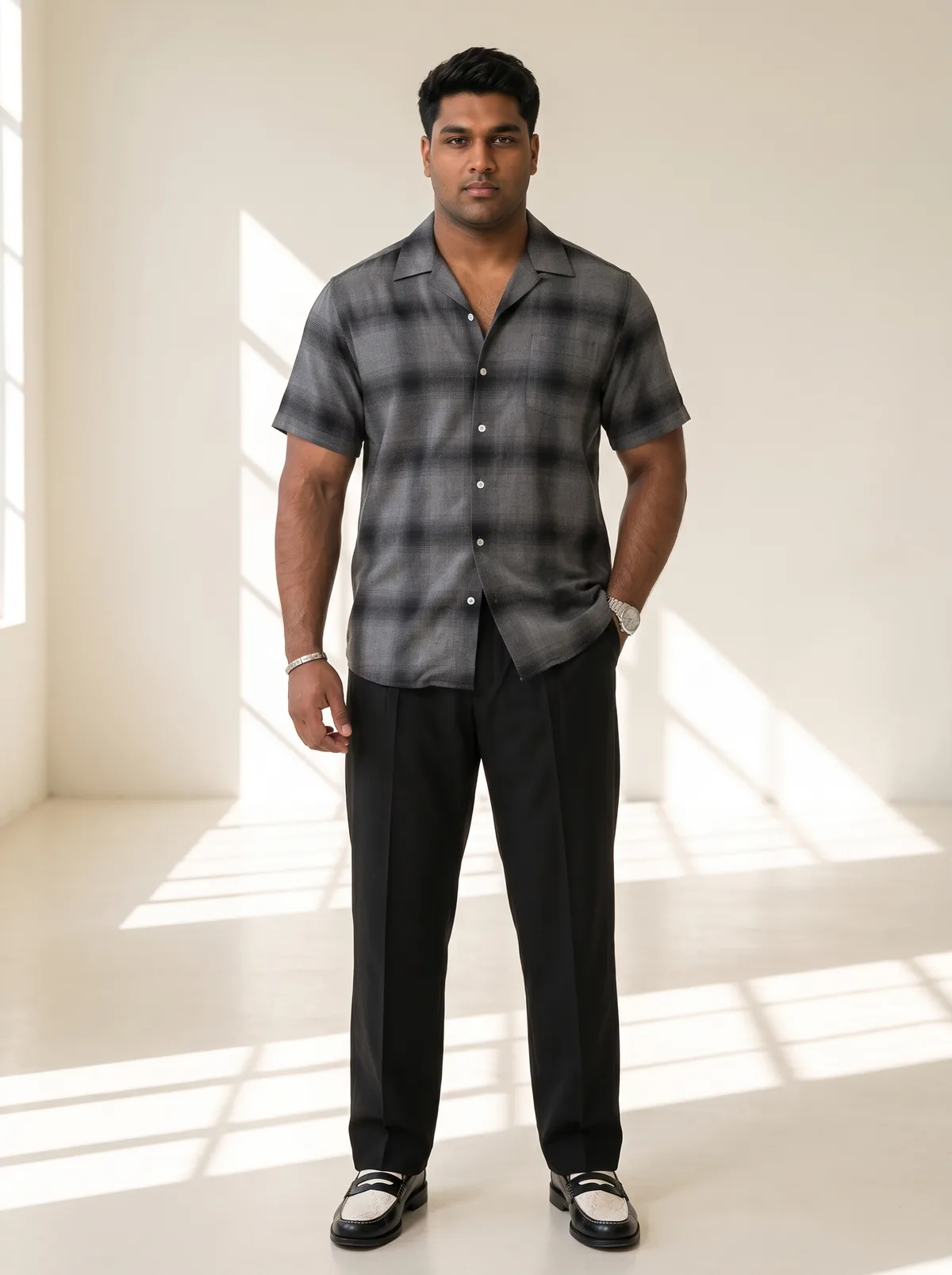 Fictional adult South Asian man wearing a dark short-sleeve shirt in a bright studio