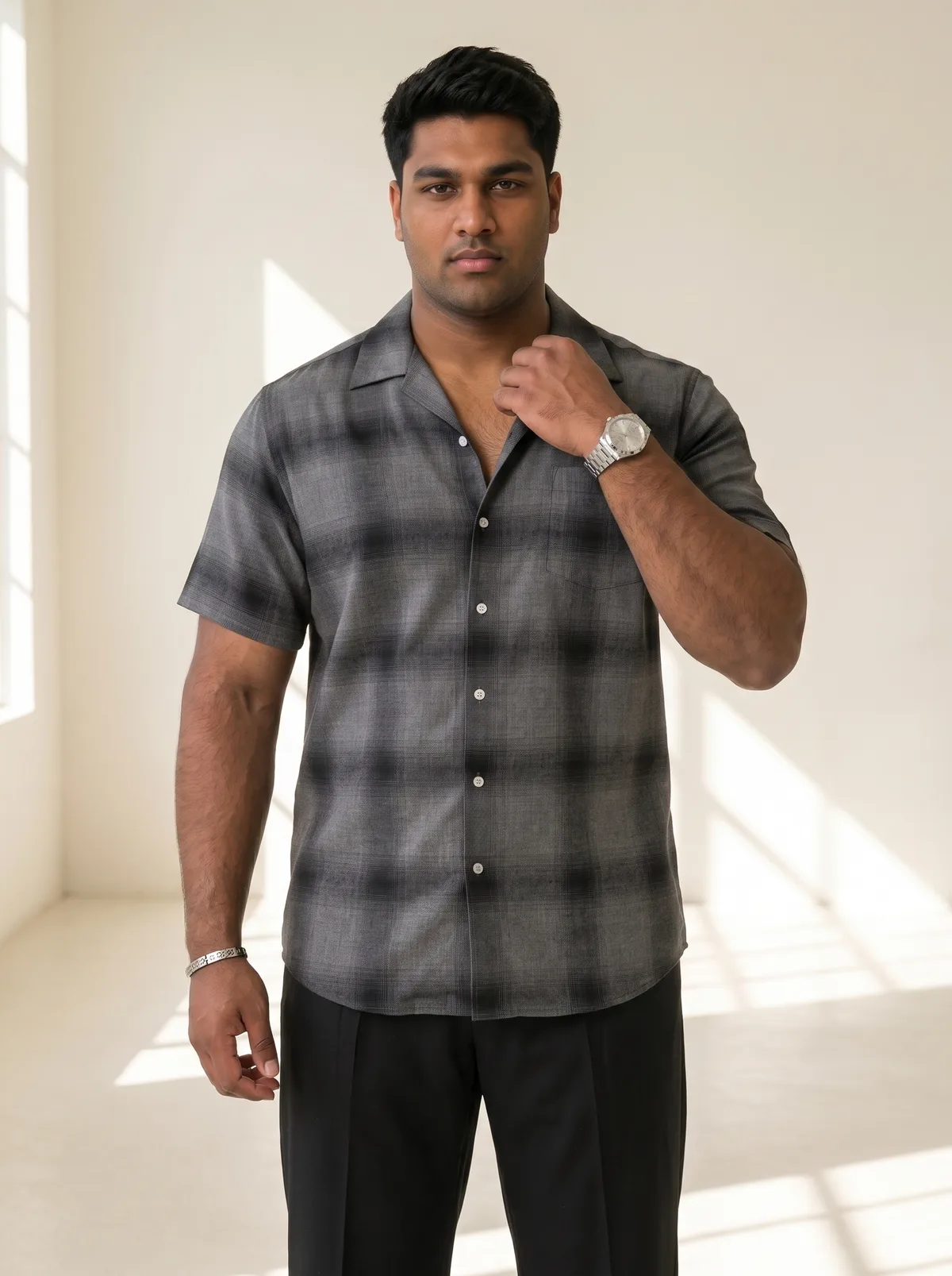 Closer fashion portrait of a fictional adult South Asian man wearing a dark checked shirt