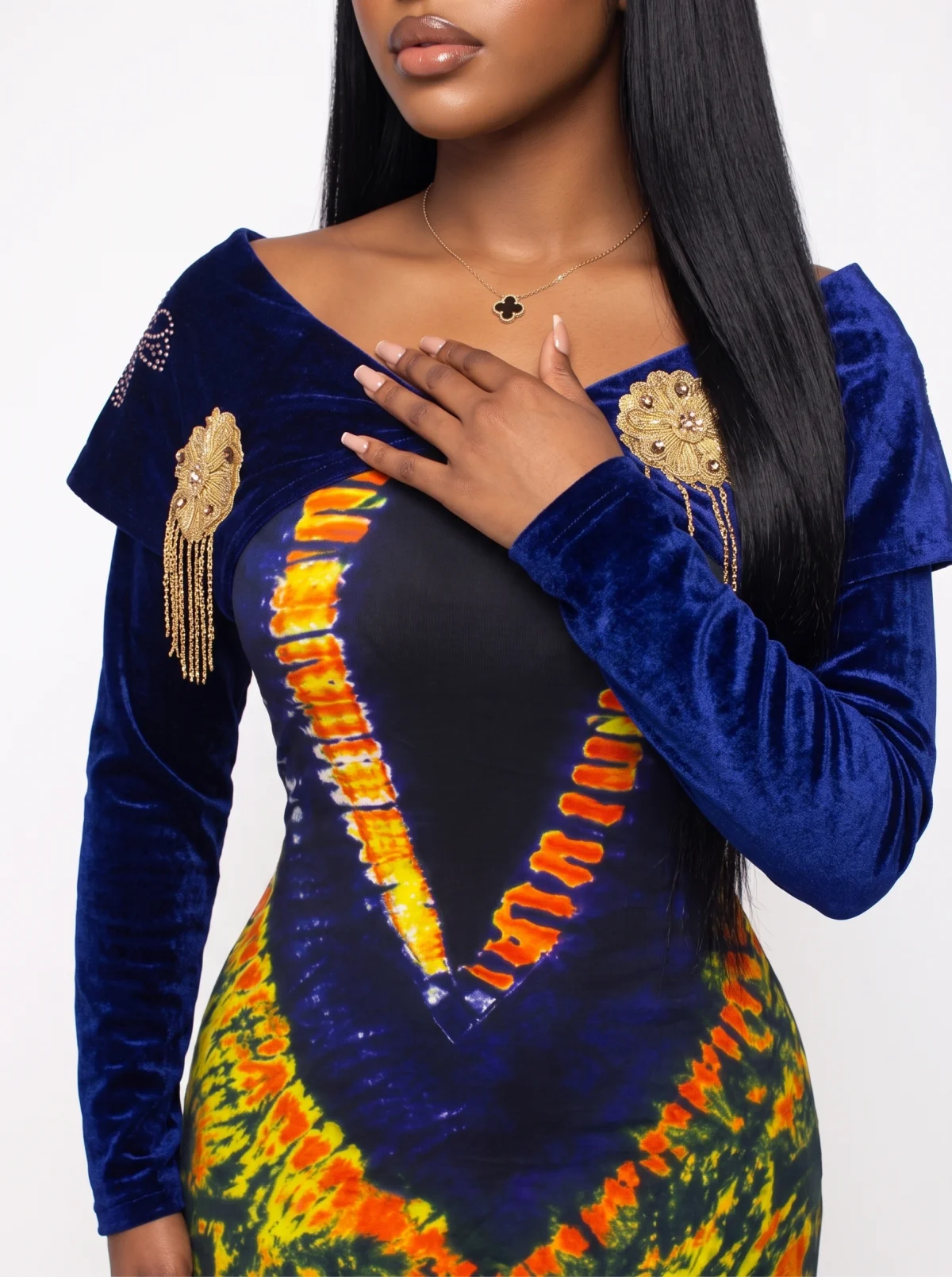 Close fashion crop showing the velvet sleeves, neckline and embellished details of a colourful dress