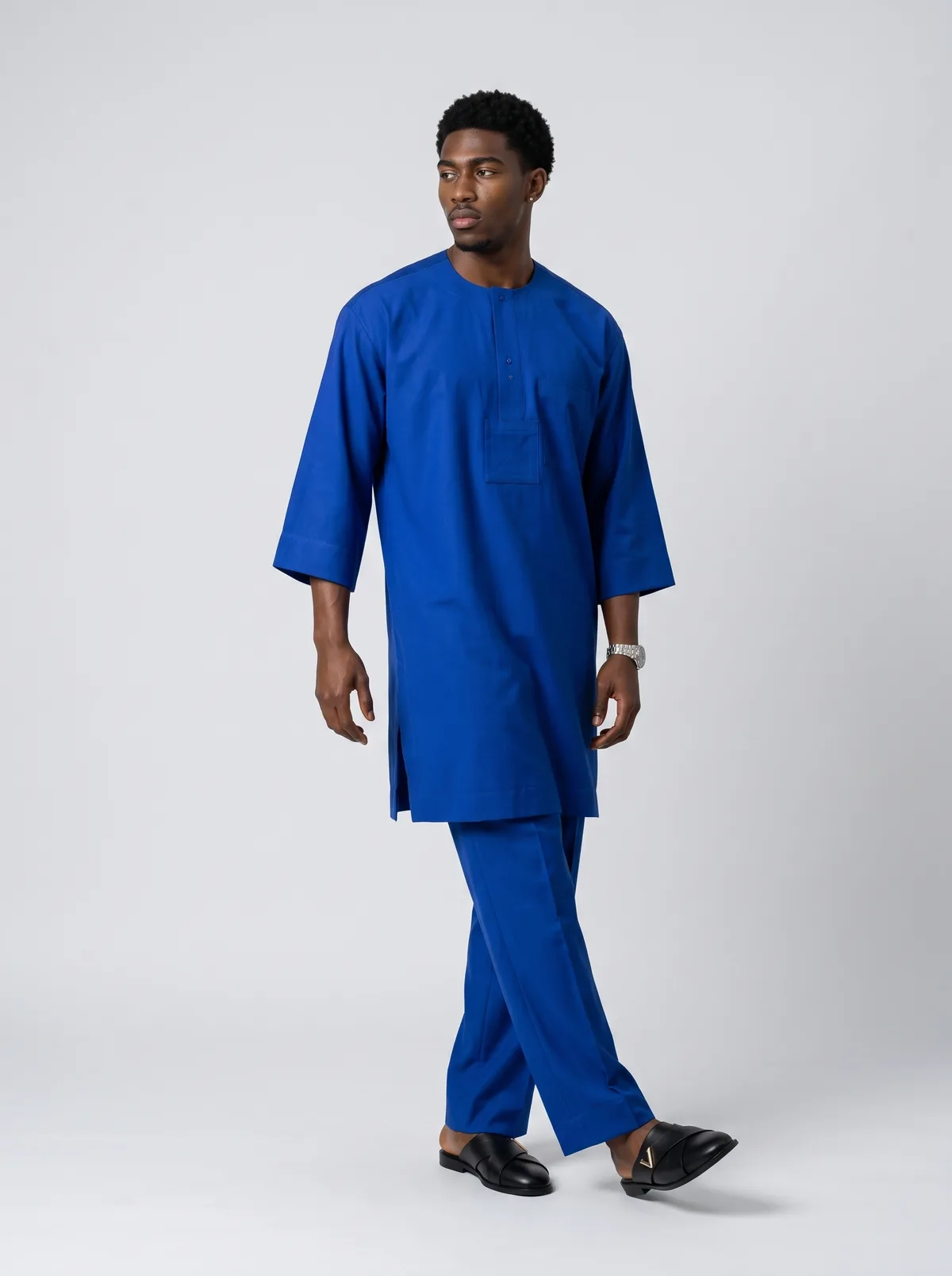 Male fashion model wearing a cobalt blue kaftan set in a full-length studio view