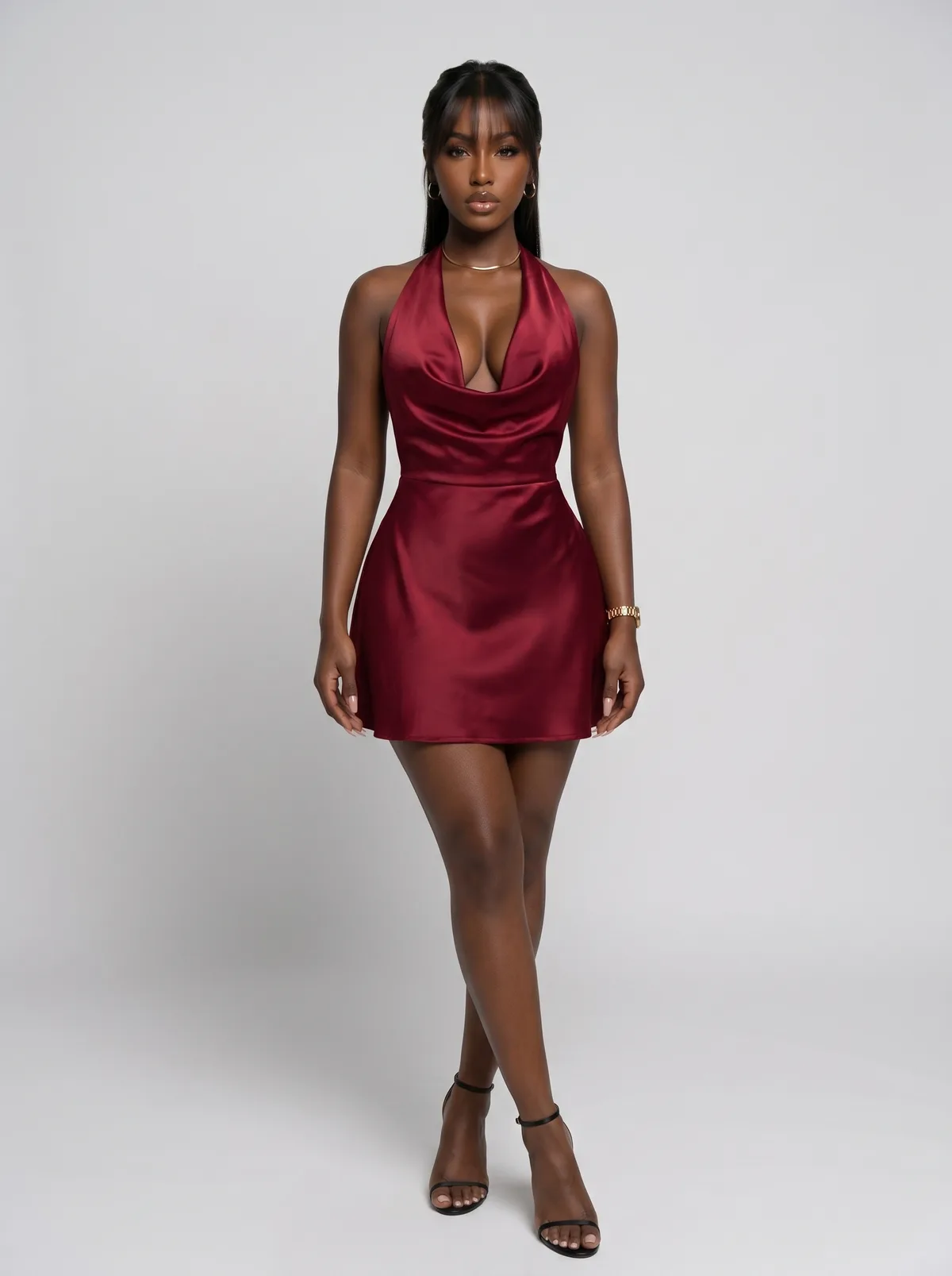 Female fashion model wearing a burgundy satin mini dress in a full-length studio view